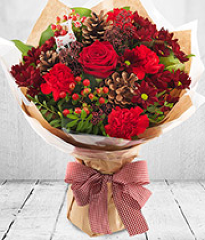 Christmas Florist Choice Hand-Tied - A festive hand-tied filled with the seasonal flowers, perfectly wrapped by the local florist and delivered in water.